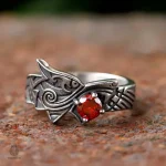 Bague en métal avec design dragon et gemme rouge